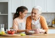 © Rizka - Happy Grandmother and Granddaughter Baking Together in the Kitchen