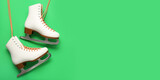 White ice skates on green background