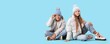© Pixel-Shot - Happy children in winter clothes sitting on blue background with space for text