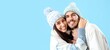© Pixel-Shot - Loving couple in winter clothes on blue background with space for text