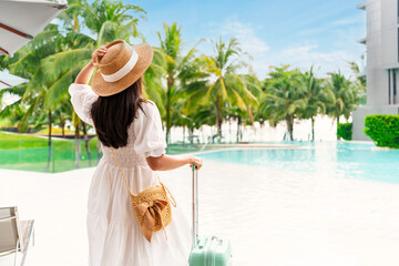 Young woman traveler enjoying a summer vacation at swimming pool in tropical resort near the beach, Travel lifestyle concept