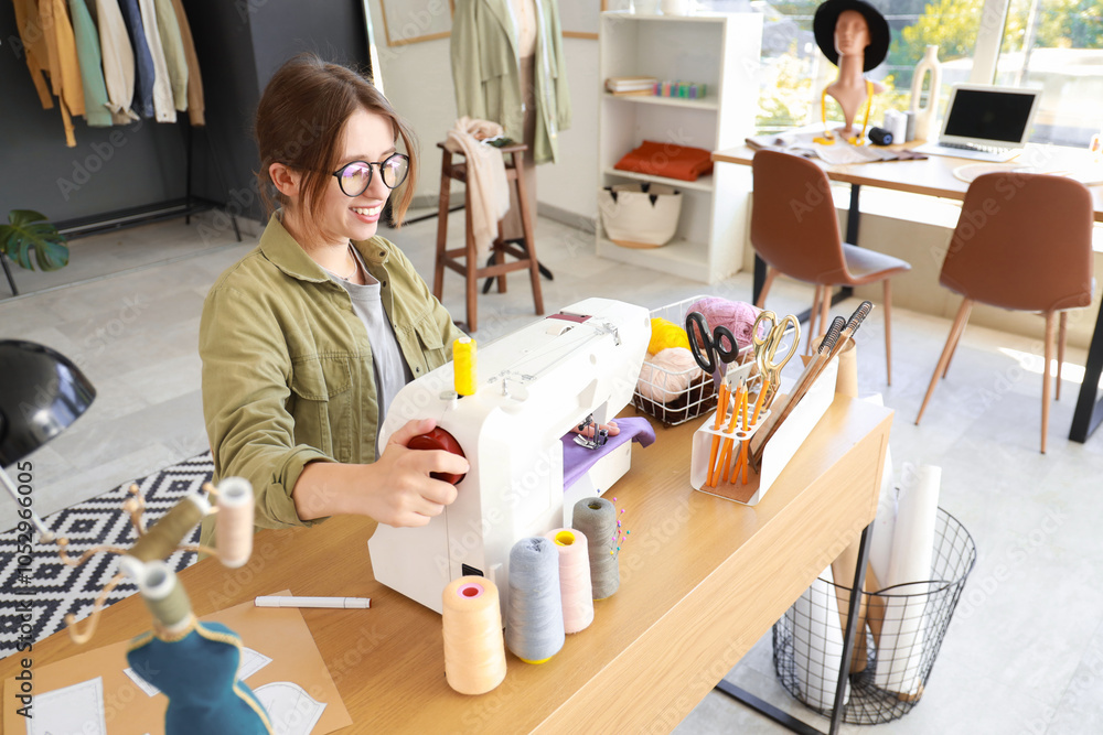 Female fashion designer sewing clothes at table in studio