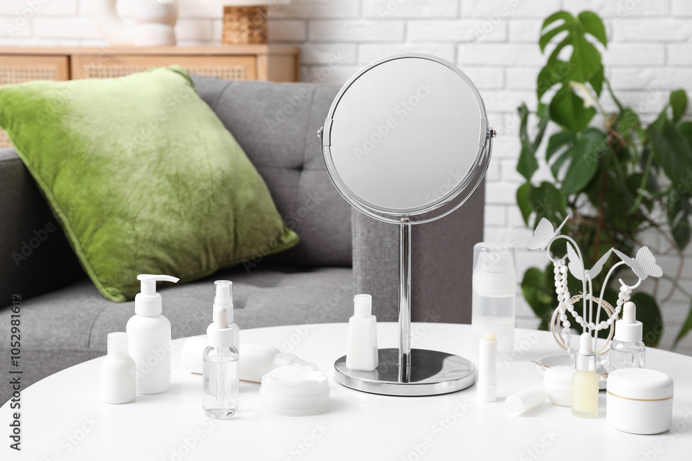 Different cosmetic products, accessories and mirror on table in room