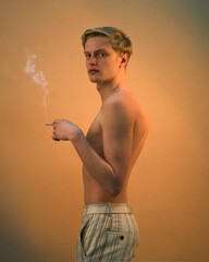 young blond man smoking cigarette. side view