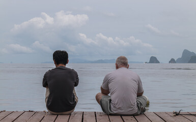 Rear view of people sitting against sea. Thailand