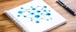 © feeling lucky - A notebook on a wooden desk featuring a blue network diagram, symbolizing connections and data visualization in technology.