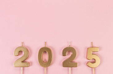 2025 Happy New Year. Top view of gold numbers on pink background. Copy space, flat lay.