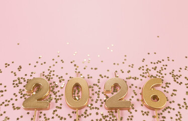 2026 Happy New Year. Top view of gold numbers, gold stars confetti on pink background. Copy space, flat lay.