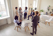 © Studio Romantic - Team and coach talking, active multiracial group of office workers brainstorming, discussing business strategy, ideas, team building activity, professional conversation during meeting conference