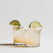 © Aleks - Two Short Margarita Glasses with Lime on White Background.