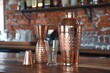 © juliars - Copper cocktail shaker and other bar tools standing on bar counter top
