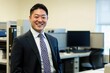 © Jaemie - Professional Japanese Man Smiling in Office Attire amid Modern Workspace, Ideal for Business and Lifestyle Themes