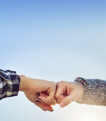 Women, hands and fist bump with blue sky background for friendship, greeting or bonding in nature. Closeup, female people or partnership with touch for unity, agreement or peace on mockup space