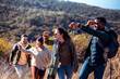 © Zoran Zeremski - Smiling group of friends having fun while hiking together on hill at sunset.
