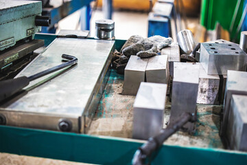 Workbench filled with various metalworking tools and materials at a manufacturing facility