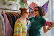 © ReeldealHD images - Female friends trying on sunglasses in a vintage clothing store for fun