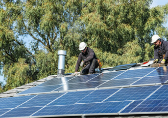 Renewable energy installation: workers on roof installing solar panels for sustainable living