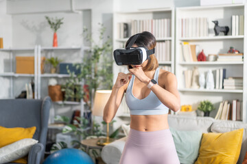 Young woman engaging in virtual reality workout session in living room, She wearing VR headset while performing boxing stance, modern technology with physical fitness, digital fitness trends at home