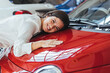 © Dragana Gordic - Joyful Woman Embraces New Red Car In Showroom Setting