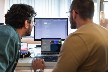 programmers engrossed in deep collaboration, diligently working together to solve complex problems a