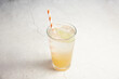 © Austockphoto - A glass of yellow soda with red and white striped straw