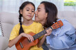 © Washburn - Happy family, mother and daughter are having fun playing music and singing