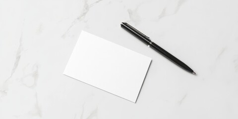 Blank card and pen on a marble surface for notes or messages.