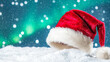 © watz - Santa hat in snow with bokeh lights in background..