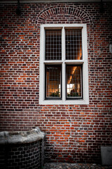 Brick wall with a window, creating a rustic architectural look.