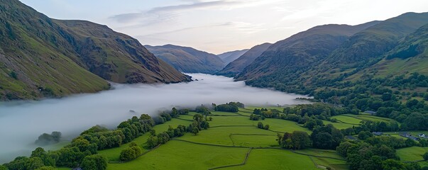 A breathtaking aerial view of a misty river surrounded by lush green hills, offering a serene and tranquil natural landscape.