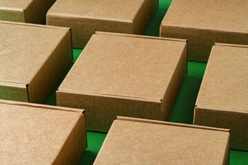 Brown cardboard boxes arranged on a vibrant green surface