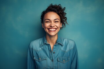 Portrait of a grinning woman in her 30s sporting a versatile denim shirt isolated in solid color backdrop