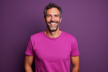 Portrait of a smiling man in his 30s dressed in a casual t-shirt on solid color backdrop