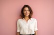 © Markus Schröder - Portrait of a content woman in her 30s wearing a simple cotton shirt while standing against solid pastel color wall