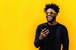 © Alfonso Soler - Portrait of handsome afro man using phone on yellow background