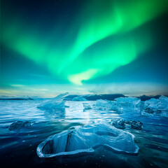 Wall Mural - Icebergs in Jokulsarlon Glacial Lagoon under incredible night sky with Aurora Borealis in Iceland. Gorgeous Icelandic landscape with icebergs and Northern lights. Polar lights