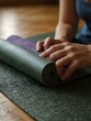 © claudunia - Rolling up a yoga mat after a session.