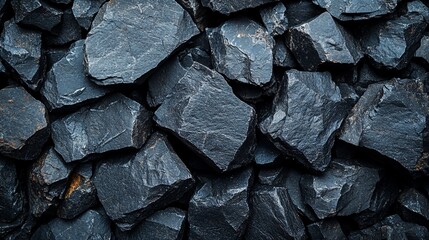 A close-up shot of a pile of dark grey rocks.