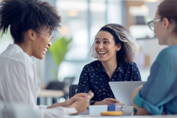 Two women colleagues share smiles and ideas during a productive workday in a modern office setting