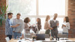 © Prostock-studio - Group of happy multiracial young people sharing ideas and having conversation while coffe break at business meeting at office, panorama