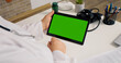 © RecCameraStock - Over the sholder shot of unrecognized female doctor watching chroma key horizontal tablet. Doctor on online conference using gadgets.