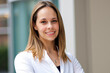 © Minerva Studio - Smiling businesswoman standing with folded arms in office building