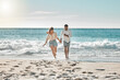 © K Davis/peopleimages.com - Playing, running or happy couple at sea to travel for love on vacation, adventure or holiday. Holding hands, wellness and people at beach for bonding together for romantic trip on tropical island