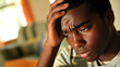 © Synaptic Studio - Stressed Man Holding Head with Worried Expression at Home.