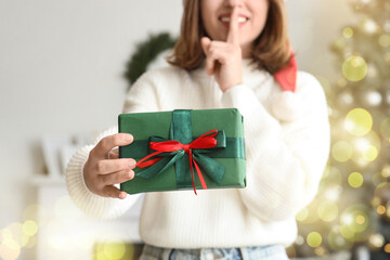 Young woman with Christmas gift box at home, closeup