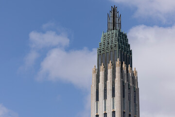 cloudy sun shines on a historic art deco church spire in downtown tulsa, oklahoma, usa.