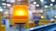 © Jiraphat - A bright orange warning light illuminates a factory, signaling an alert in a busy industrial environment.