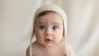 © Nemanja - Cute Baby with Blue Eyes Wearing Knitted Hat in Neutral Expression