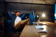 © peopleimages.com - Businessman, laptop and relax for project management, networking and communication in office at night. Employee, technology and success for development proposal, report or research with late deadline