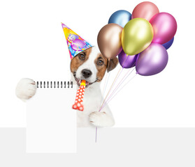 Poster - Happy jack russell terrier puppy wearing party cap holds balloons and shows empty list above blank white banner. Empty space for text. isolated on white background